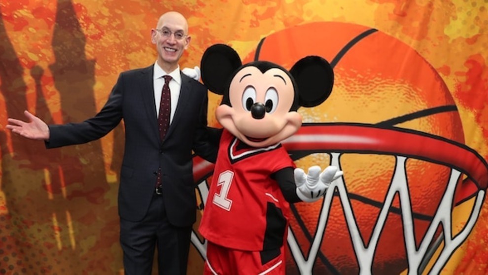 Adam Silver, comisionado de la NBA, posa con Mickey Mouse en un acto...