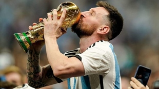 Leo Messi besa el trofeo de la Copa del Mundo.